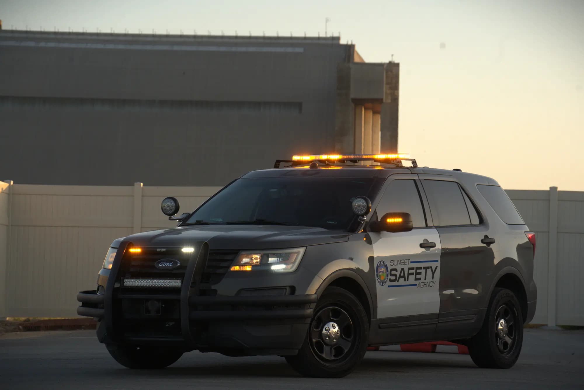 Explorer patrol SUV with lights lit at dusk in front of an industrial hangar