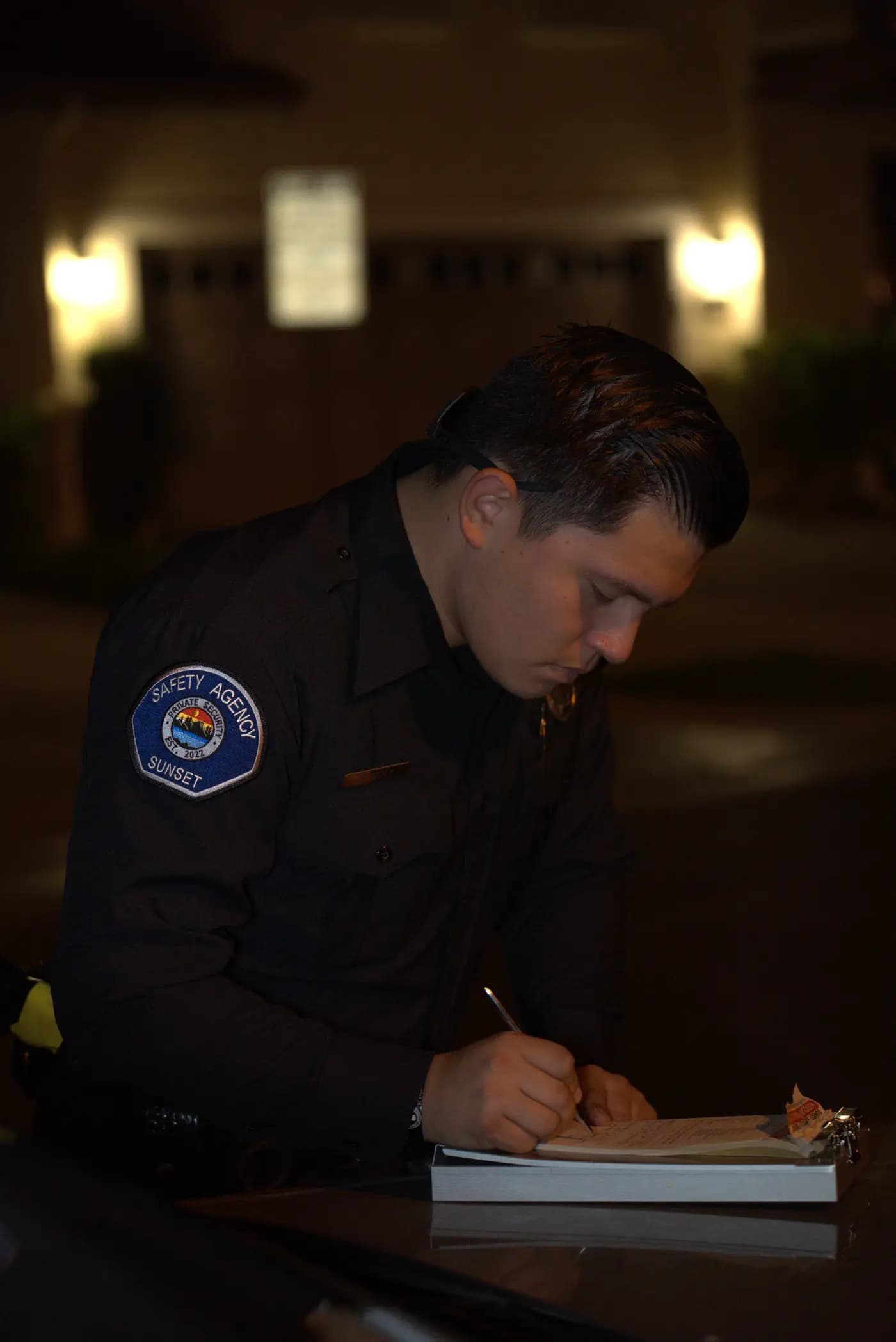 Officer writing a parking citation in an apartment carport at night