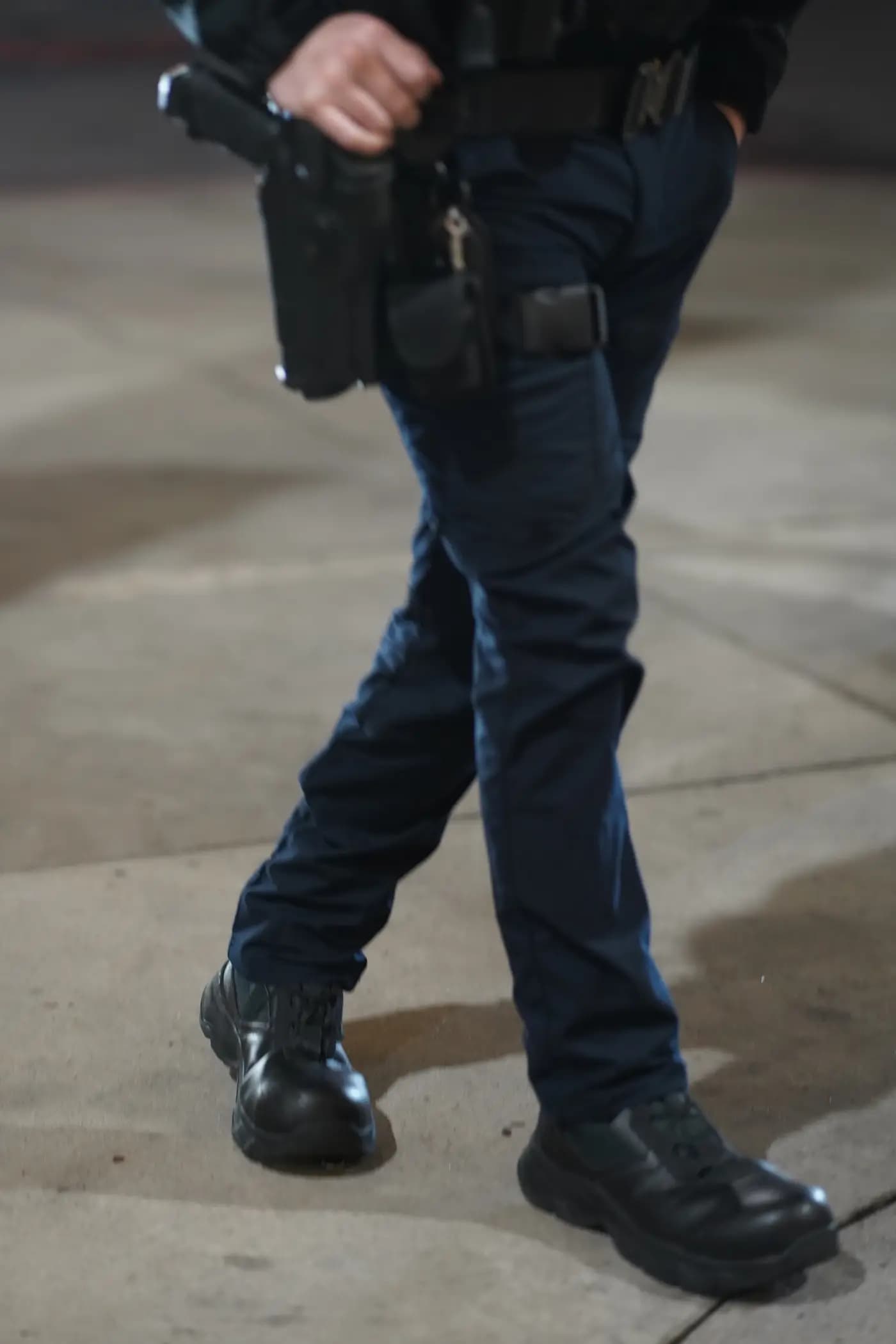 Detail of an officer's duty belt and holster mid-stride