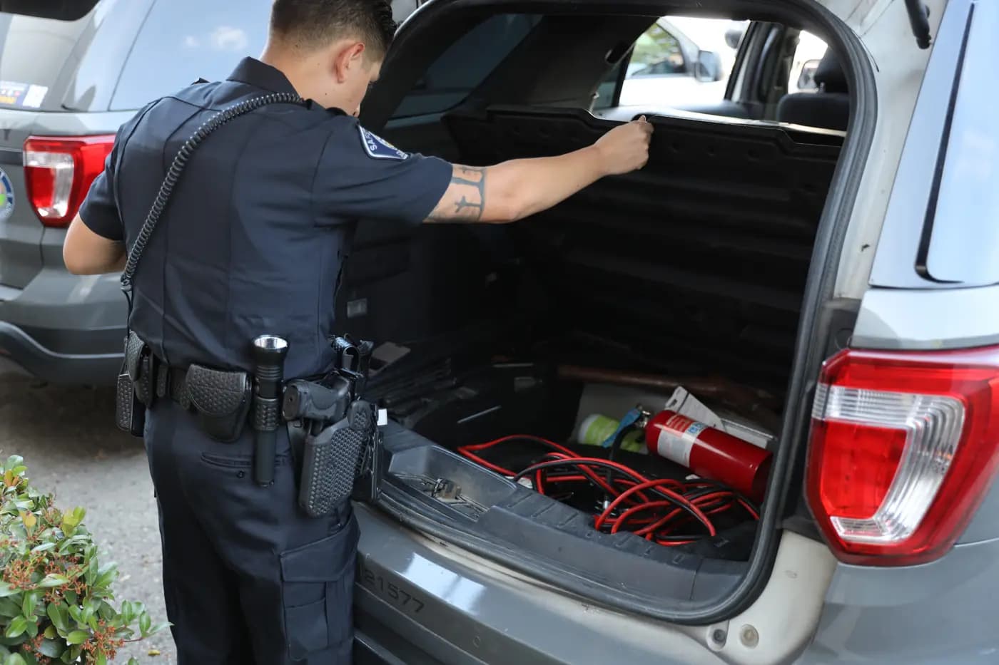 Officer checking equipment in the cargo area of a patrol SUV