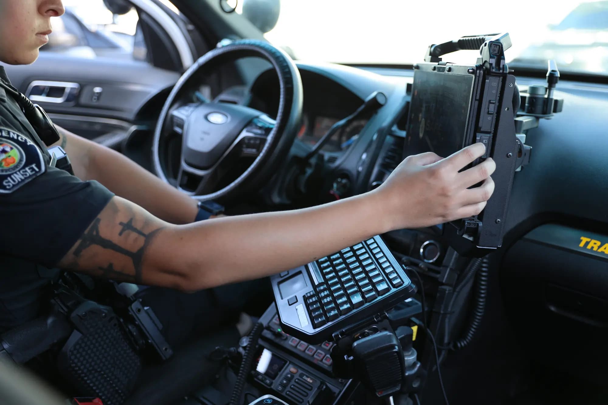 Officer adjusting the rugged mounted data terminal in a patrol SUV