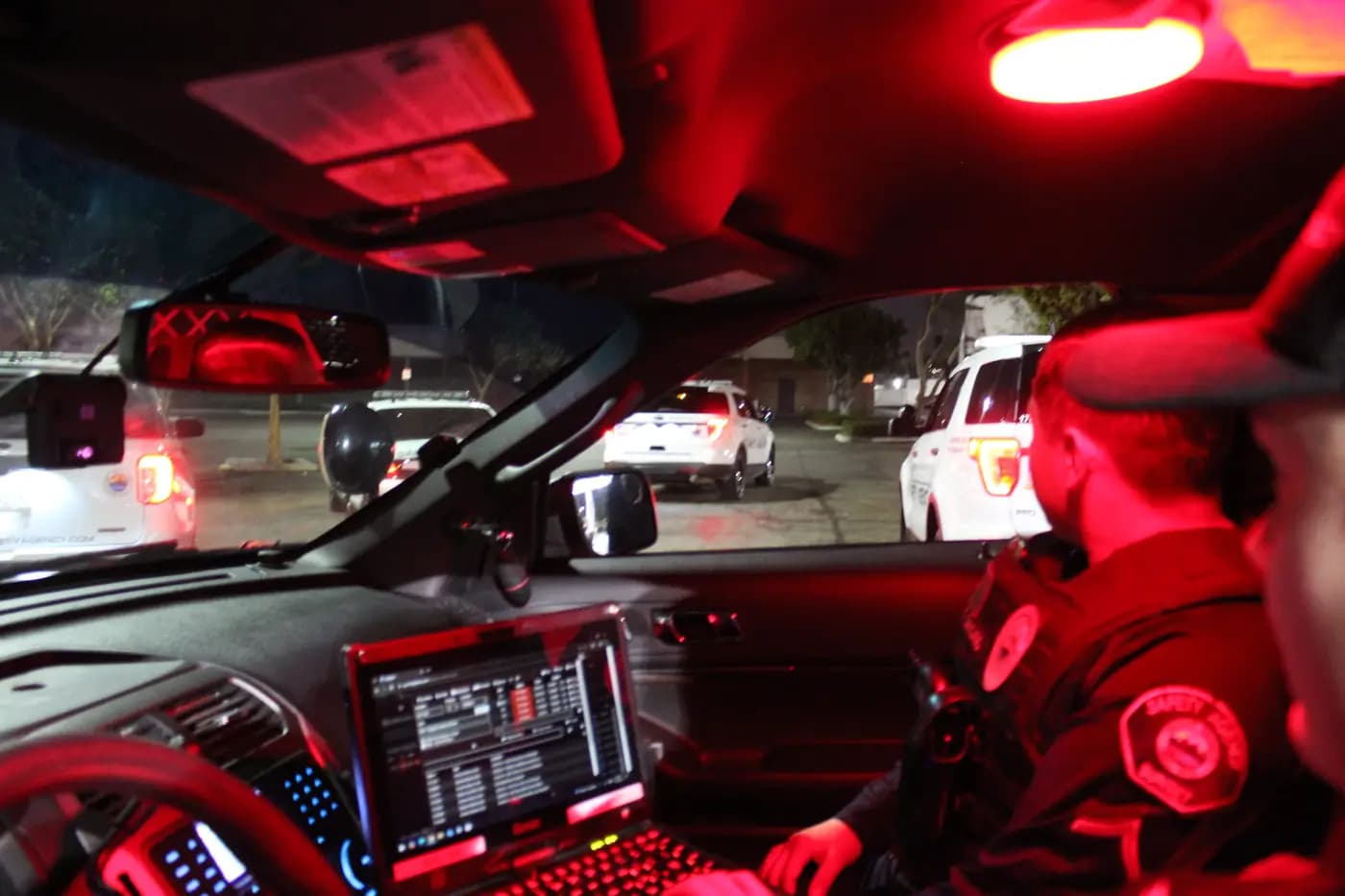 Patrol vehicle cockpit under red night light with the data terminal glowing
