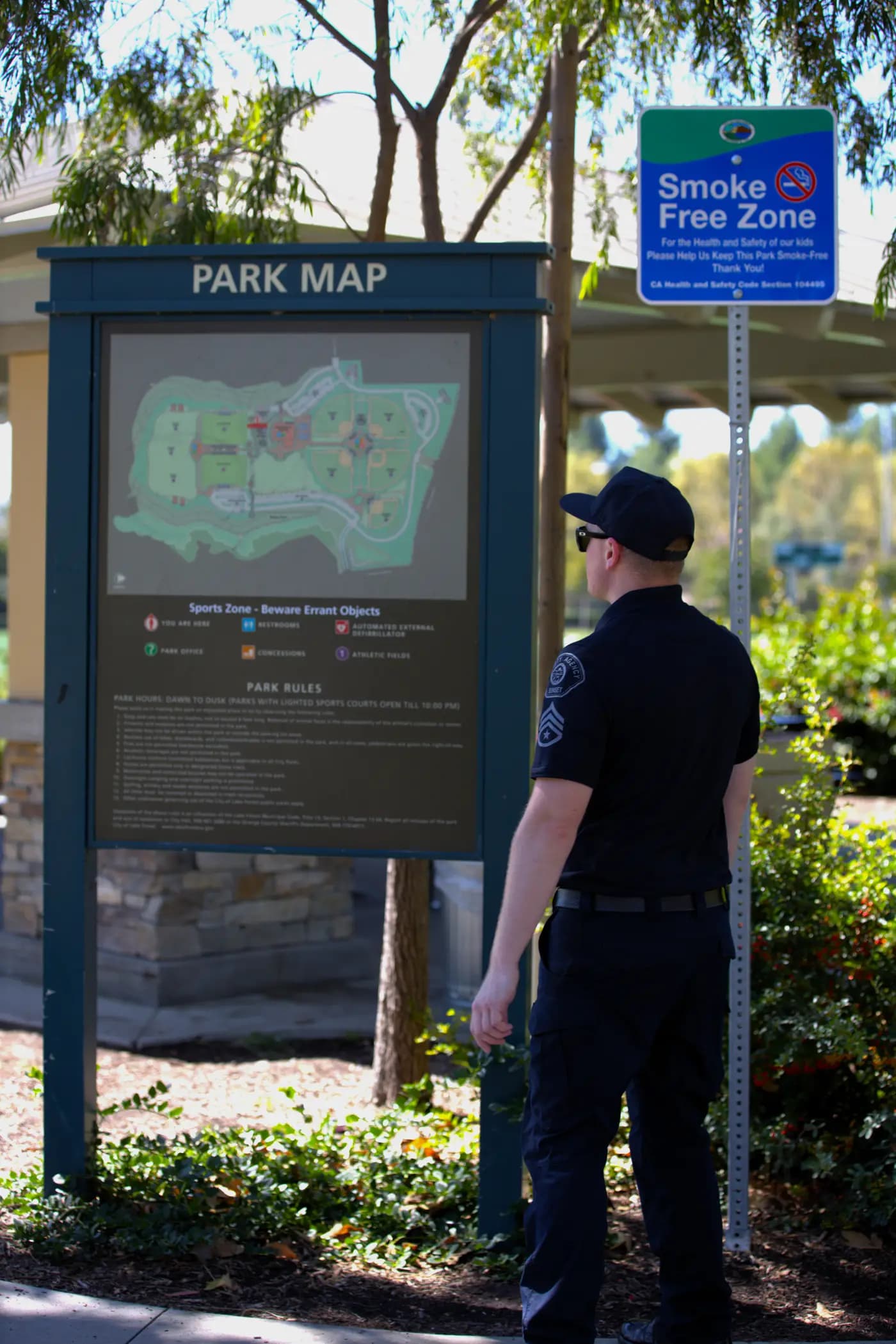 Officer reviewing a park map and rules kiosk on an ordinance patrol