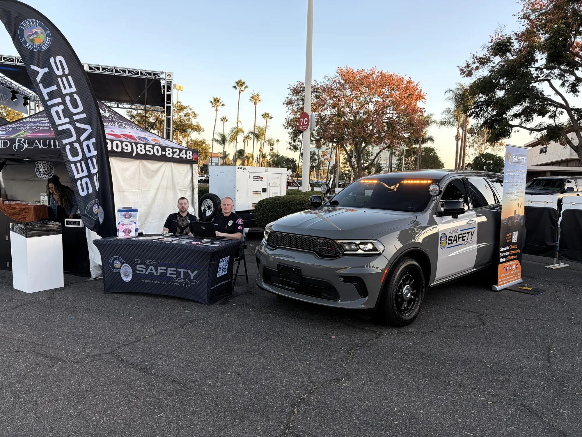 Officers at the branded booth with a patrol Durango at a golden-hour community event