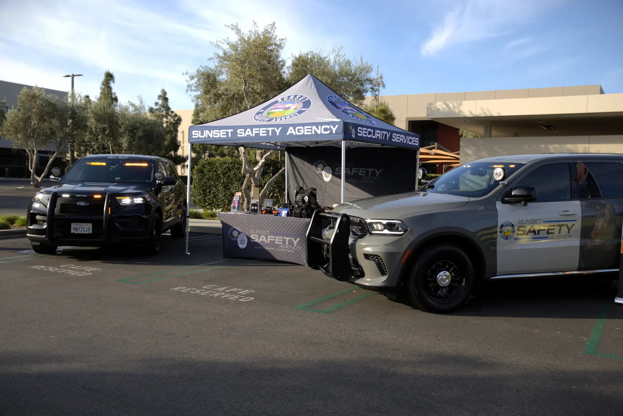 Branded event canopy with gear display flanked by two marked patrol SUVs
