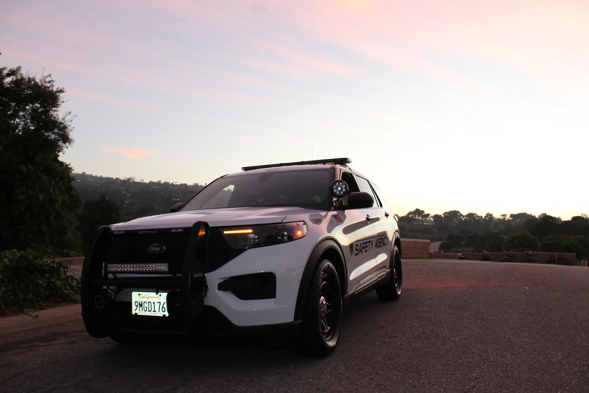 Supervisor patrol SUV parked on a quiet hillside road under a soft pink dawn sky