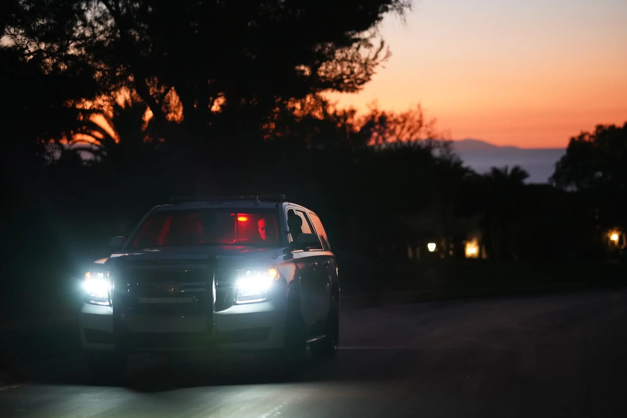 Marked patrol Tahoe driving a residential street at sunset