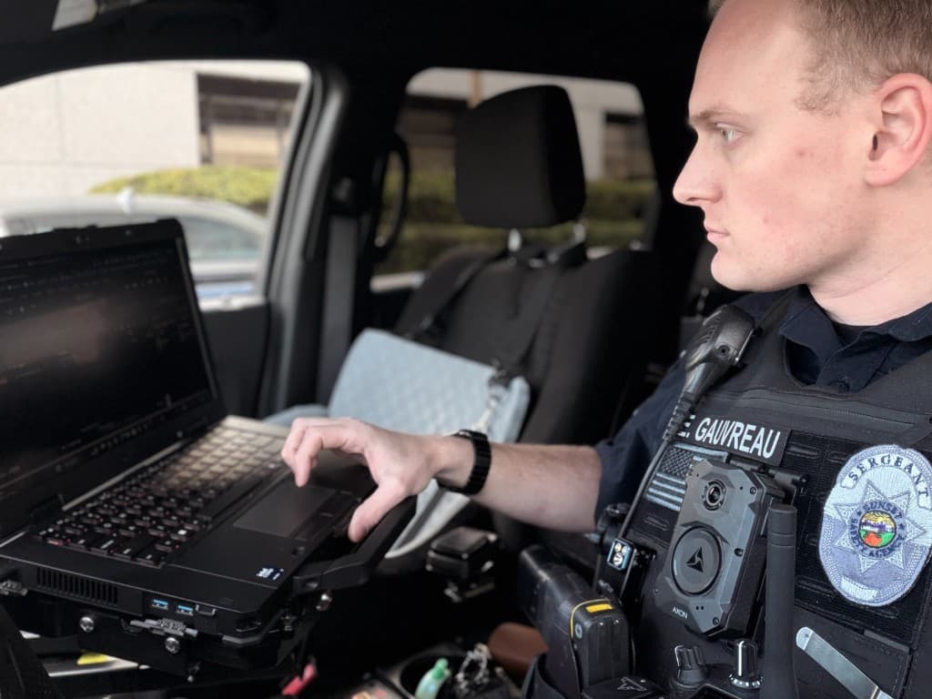 Evan Gauvreau, founder, using mobile data terminal in patrol vehicle
