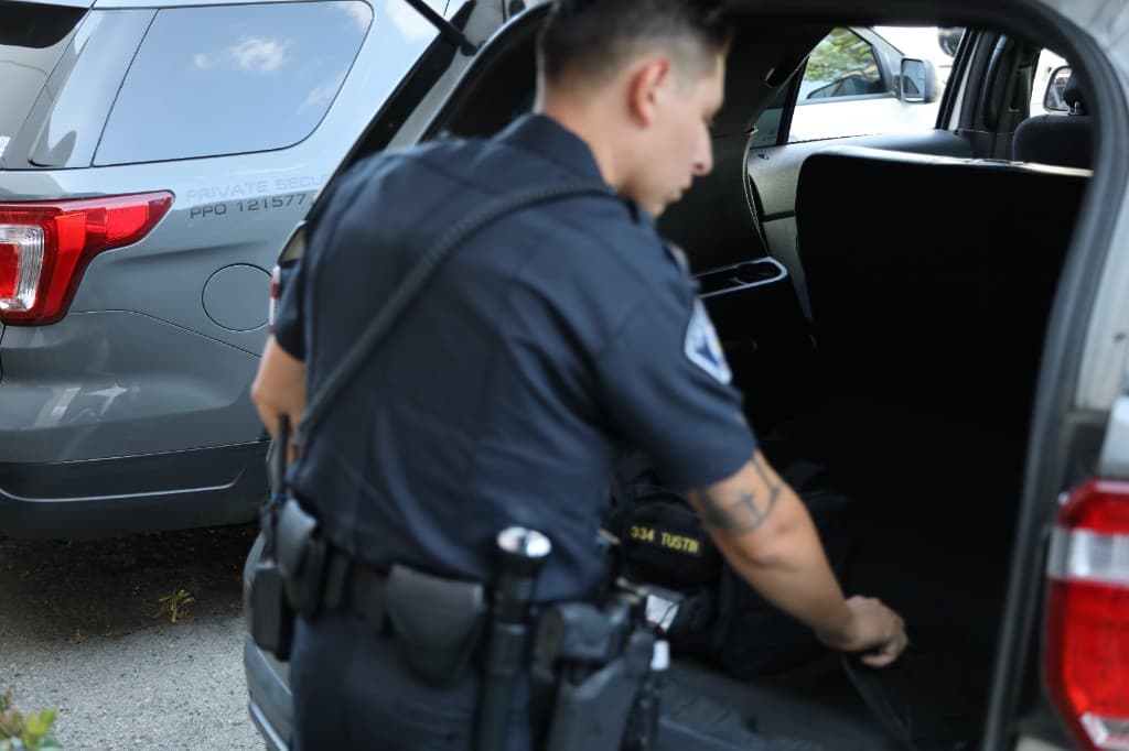 Officer preparing emergency equipment in patrol vehicle trunk