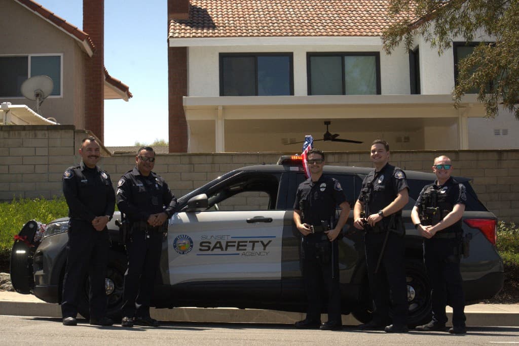 Sunset Safety Agency officers at an Independence Day community event with patrol fleet